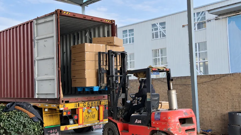 Forklift loading packed products into a shipping container